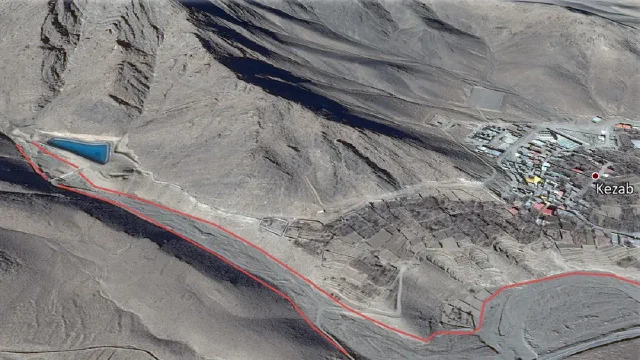 Satellite map showing a river channel traced in red beside the village and a blue pool