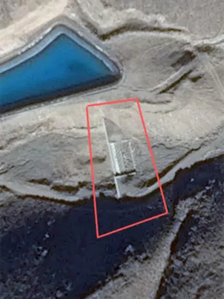 Satellite view of a concrete structure outlined in red below a blue pool